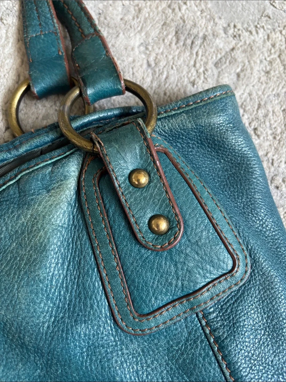 The Sak Teal Leather Shoulder Bag distressed has been loved and used.
